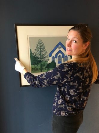 Laura Woodward, Wellington City Council Collections Registrar with artwork by Robin White titled Southland Monkey Puzzle, 1973